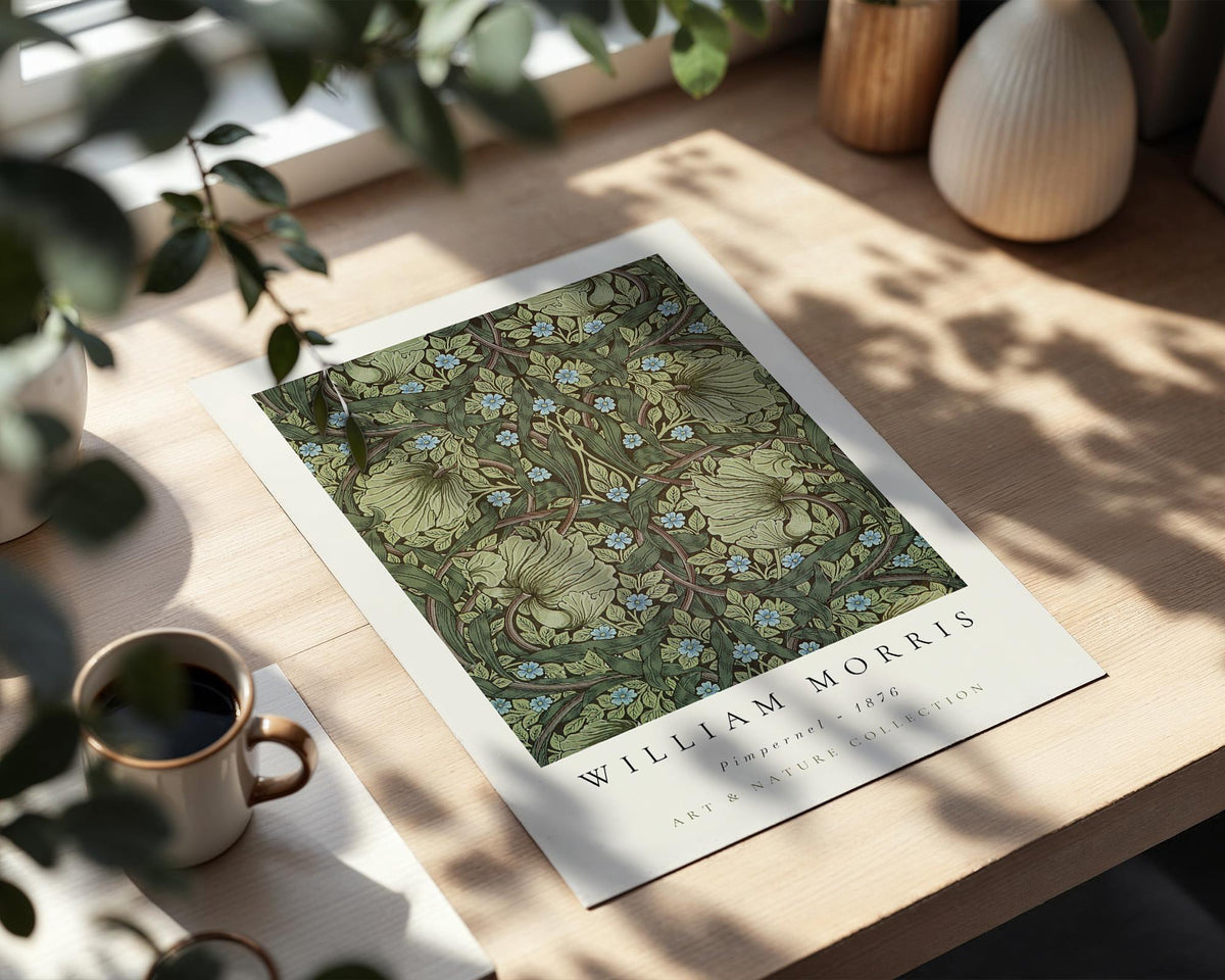 a poster of William Morris' Art & Nature Collection, displayed on a wooden table with a cup of coffee nearby.