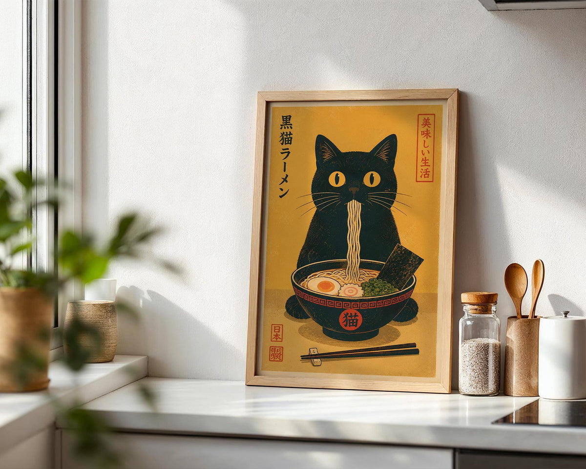 a framed illustration of a black cat sitting in a bowl of noodles, with chopsticks and a spoon nearby.