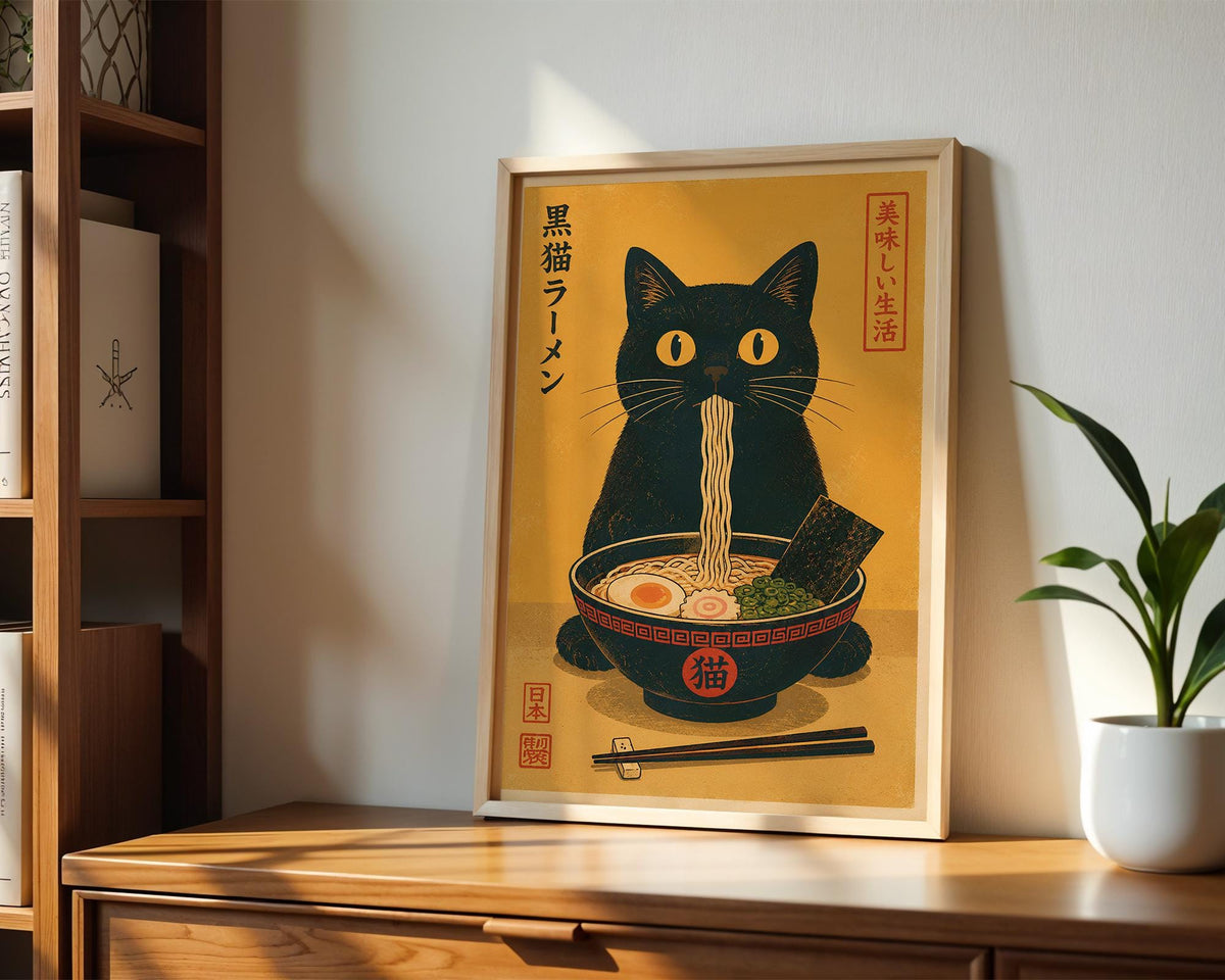 a framed illustration of a black cat sitting in a bowl of noodles, with chopsticks and a plant in the background.